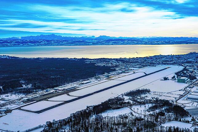 Der verschneite Flughafen, nur die Landebahn hebt sich deutlich ab.