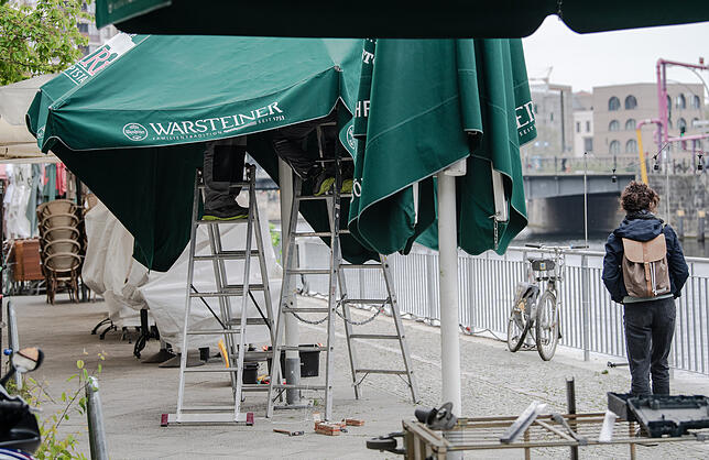 Arbeiter reparieren einen Sonnenschirm eines gastronomischen Betriebes in Berlin Mitte. Da die Inzidenzen bei den Corona-Erkrankungen ...