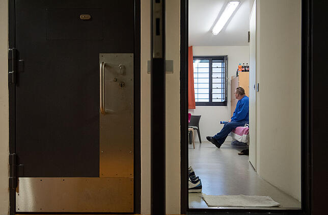 Ein Insasse der Justizvollzugsanstalt (JVA) Stuttgart im Stadtteil Stammheim sitzt in seiner Einzelzelle, links ist die Tür einer ...