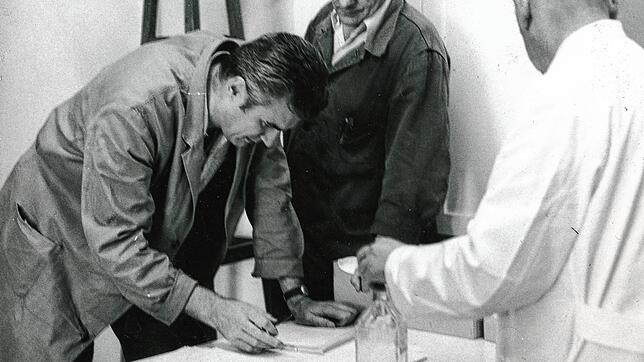 Grippeimpfung 1972 in der Brennet AG: Links ein Belegschafter, der sich die Unterlagen anschaut, rechts der Werksarzt, der gleich impfen ...