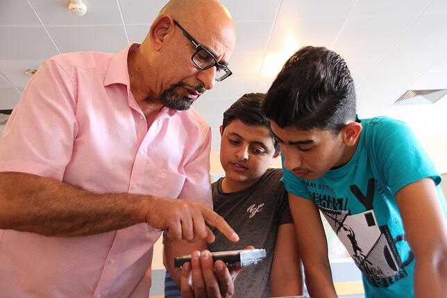 Selbst mitanpacken ist bei den Reboots gefragt (v.l.): Adil Asfoor zeigt Ilyas Ilyas und Saman Dawood wie sie ihre kaputen Geräte wieder ...