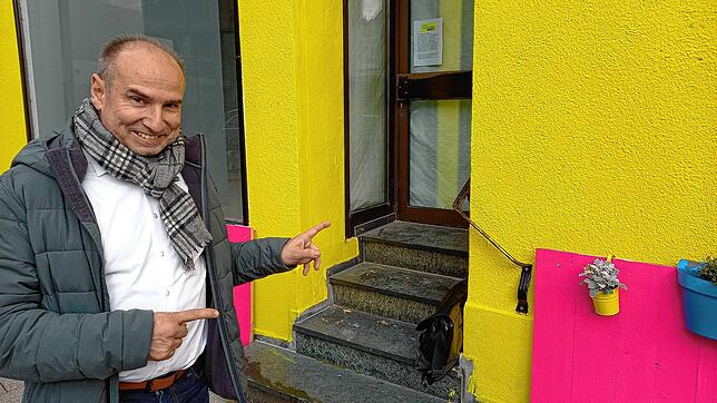 Hier ginge es rein, wenn man noch dürfte: Der FDP-Vorsitzende Rolf Haas zeigt auf die Eingangstür des gelben Hauses in der Hauptstraße ...