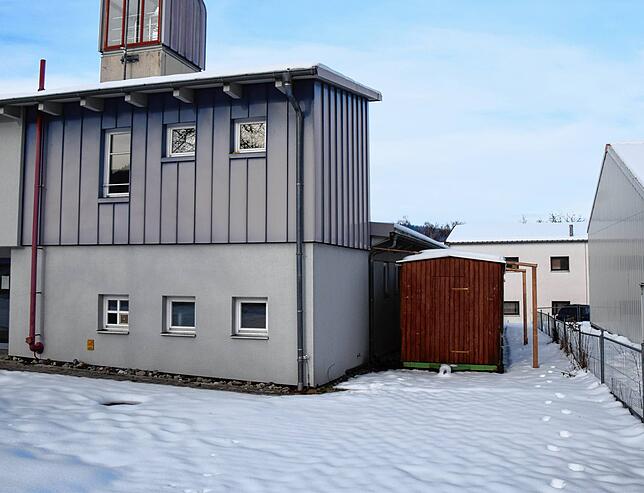 Rechts vom Feuerwehrhaus, wo die Holzhütten zu sehen sind, soll der Anbau mit Eingang entstehen.