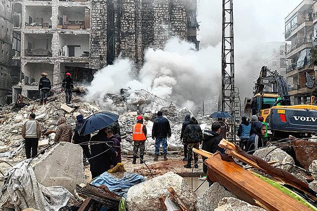 Ein von der amtlichen syrischen Nachrichtenagentur SANA veröffentlichtes Foto zeigt Rettungskräfte und Menschen, die versuchen mit ...