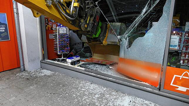 Krasser Anblick: Die Schaufel des Baggers hängt im November Schaufenster des Elektrogeschäfts.