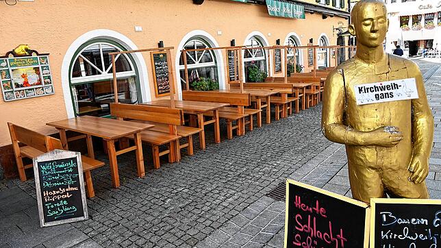 Leere Tische und Bänke stehen vor einem Lokal im Ortskern von Berchtesgaden.
