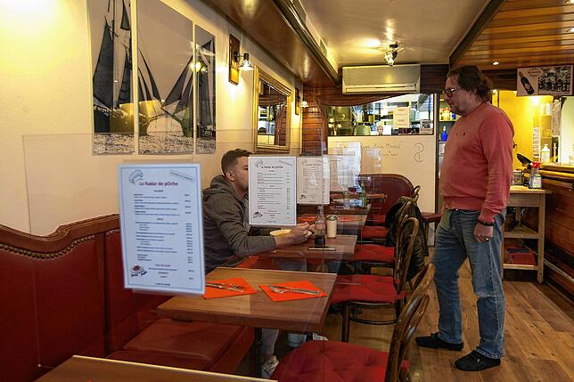 Blick in das Restaurant „Radar de Poche“ in der Stadt Genf: Plexiglasscheiben zwischen den Tischen trennen die Gäste ...