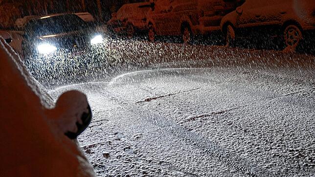 Autos im Schneetreiben auf verschneiten Straßen (Symbolbild). Schneefall legt im Kanton Aargau teils den Verkehr lahm, und die Polizei ...
