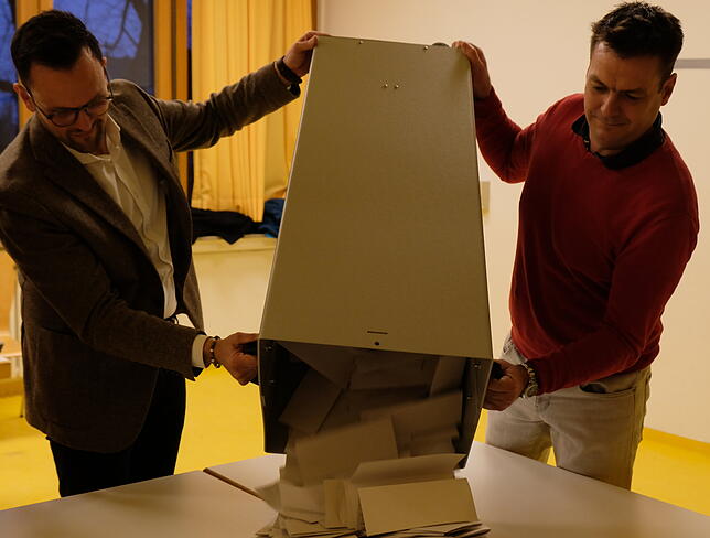Bürgermeister und Wahlhelfer Johannes Henne und Meinrad Schneider leeren in Immenstaad eine Wahlurne aus.