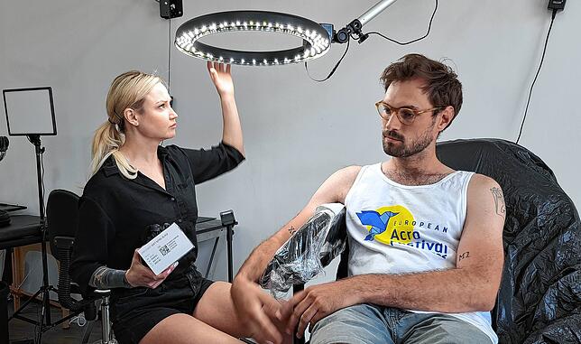 Gleich geht&lsquo;s los. Künstlerin Ekaterina Gerasimova bereit richtet sich das Licht, um anschließend das Opt.Ink-Zeichen in Simon ...