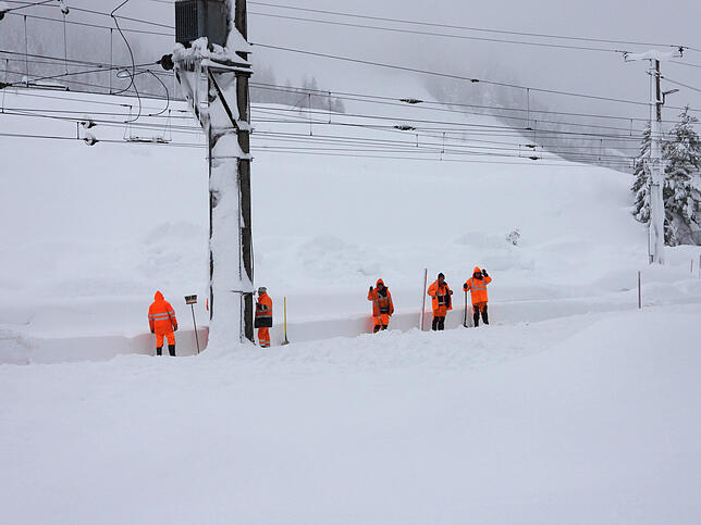 Österreich, Hochfilzen: Arbeiter stehen an einer eingeschneiten Bahnstrecke. Aufgrund von starken Schneefällen kommt es zu ...