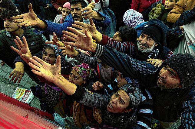 Freiwillige Helfer verteilen Hilfsgüter an Menschen in Antakya.