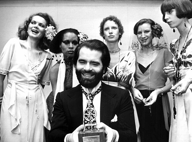 Modedesigner Karl Lagerfeld zeigt sich 1973 bei einer Auszeichnung in Krefeld inmitten einiger Models. Seit Anfang der 1950er-Jahre ...