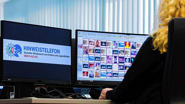 Eine Ermittlerin der Kriminalpolizei sitzt vor Monitoren mit unkenntlich gemachten Fotografien, die teilweise sexuellen Missbrauch zeigen.