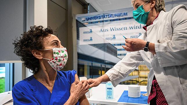 Zeynep Kallmayer (l), Pflegegruppenleiterin am Frankfurter Uniklinikum, schaut nach ihrer Impfung am 27.10.2020 zu Sabine Wicker, ...