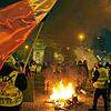 Demonstranten mit gelben Westen stehen neben einem brennenden Fahrrad auf der Champs-Elysees. Mit deutlich weniger Teilnehmern als noch ...