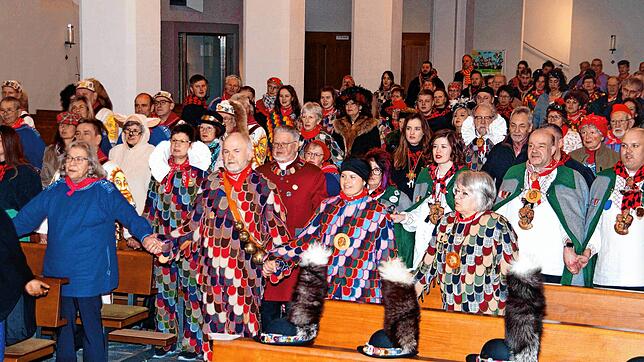 Beim Vater Unser geben sich die Narren in der sehr gut besuchten Pfarrkirche über den Mittelgang hinweg die Hand.