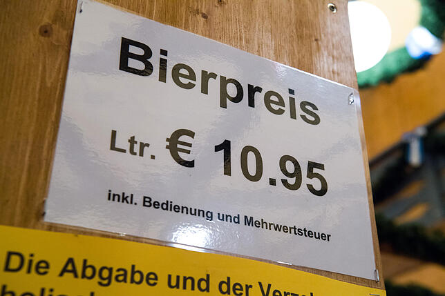 Ein Schild mit der Aufschrift "Bierpreis - Lt. Euro 10.95" hängt in einem Bierzelt auf dem Oktoberfestgelände.