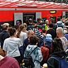 Reisende versuchen auf einem überfülltem Bahnsteig im Hauptbahnhof Köln in einen Regionalzug zu steigen.