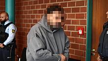 Grauer Kapuzenpullover, Hand- und Fußfesseln, müder Blick: Der Beschuldigte hat bereits am ersten Tag die Tat gestanden.