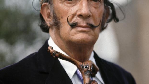 ARCHIV – Der spanische Künstler Salvador Dali schaut am 17.09.1968 auf dem Gelände seines Wohnsitzes an der Costa Brava (Spanien) in die ...