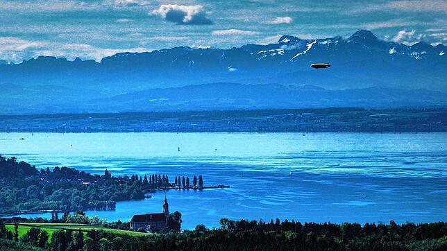 Malerisch: Ein Zeppelin fliegt über den Bodensee Richtung Friedrichshafen, während im Vordergrund die Barockkirche Birnau zu sehen ist.