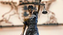Die Justizia vor dem baden-württembergischen Landeswappen eines Gerichts.