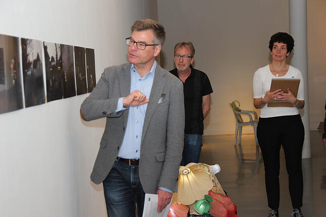 Christoph Bauer, Leiter des Kunstmuseums, erläutert Werke der aktuellen Aussellung, hier eine Fotoserie von Roger Aupperle. Mit im Bild ...