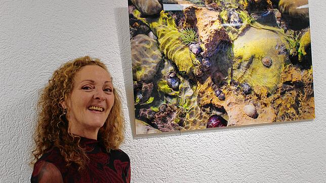 Iris Faller steht vor ihrem Lieblingsbild der Ausstellung in Gailingen. Foto: Ingrid Ploss