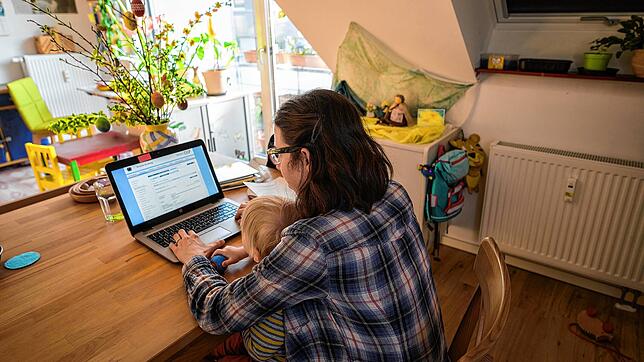 Tippen mit dem Kind auf dem Schoß: Beruf und Familie im Homeoffice unter einen Hut zu bringen, ist nicht immer einfach. Bild: dpa