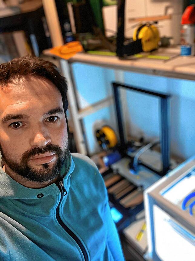 Mitinitiator Simon Blust neben einem 3D-Drucker.