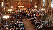 Die gut 100 Sänger und Musiker füllen fast den gesamten Altarraum aus, als sie zum Schluss des Konzerts gemeinsam das Stück „Dorfkind“ ...