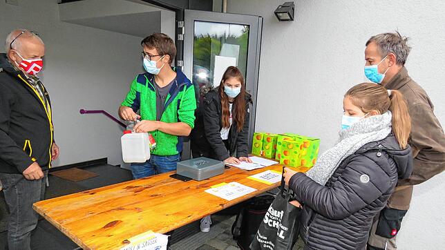 Getränke aus Streuobst und Zwiebelkuchen: Isabell und Stefan Frank holen ihre Bestellung ab. Hinter der Theke stehen Andreas Honold und ...