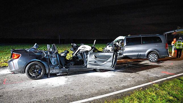 Zwei Fahrzeugwracks stehen auf der Straße am Ostring in Eggenstein nach dem schweren Unfall, bei dem fünf Menschen ums Leben gekommen sind.