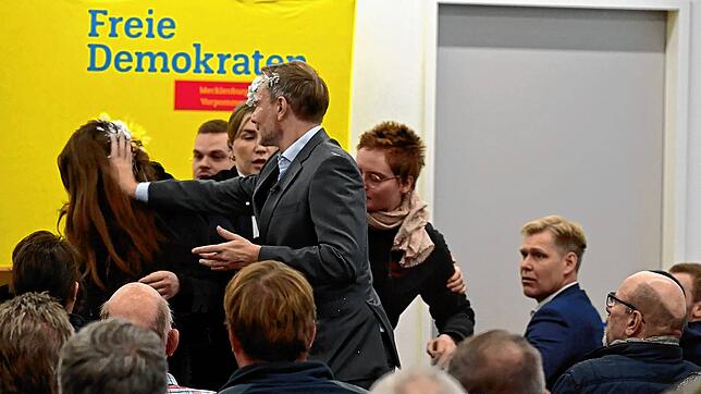 Lindner schmiert der Frau ein Teil des Schaumes zurück in die Haare.