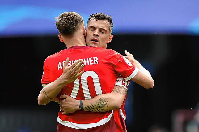 Die Schweizer Michel Aebischer (l) und der Granit Xhaka umarmen sich nach dem Spiel.