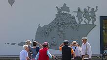 Peter Lenk (rechts mit Hut) mit den ersten Betrachtern des Kunstwerks "Das Narrenschiff".