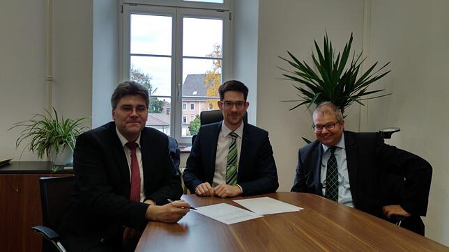 Die Entscheidung: Bürgermeister Alexander Guhl (rechts) und Landrat Martin Kistler (links) schließen vor Notar Kai-Christoph Stadler ...