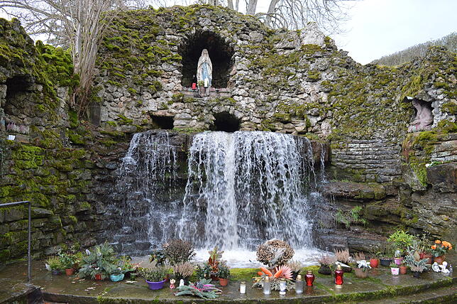 Herzstück der Lourdesgrotte in der Elsenau ist die Madonna in der Felsnische über dem Wasserfall