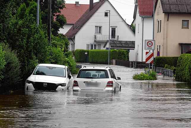Offingen: Autos stehen im Hochwasser der Mindel in einem Wohngebiet.