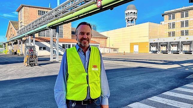 Maggi-Werksleiter Pascal Moser steht direkt unter den Rohrleitungen, in denen das Thermoöl von Fondium zum Maggi-Kesselhaus (hinten ...