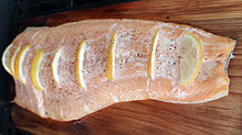 Lachs auf dem Zedernbrett gegrillt, bekommt ein feines rauchiges Aroma.