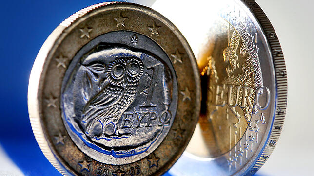 Eine griechische Euro-Münze steht auf einem Leuchttisch.