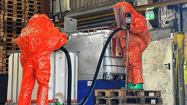 Mit entsprechender Schutzkleidung pumpt die Feuerwehr das Wasserstoffperoxid in einen unbeschädigten Behälter um.