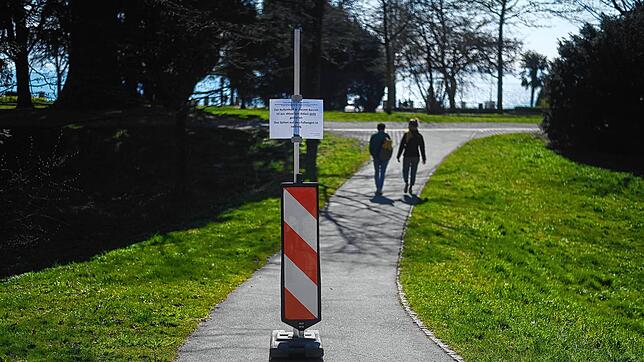 Unübersehbar: An allen Zugängen zur Friedrichshafener Uferpromenade stehen Hinweisschilder, dass der Durchgang erlaubt, das Verweilen ...