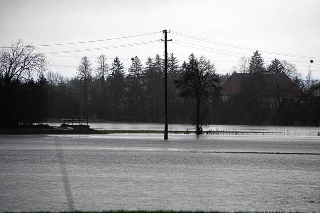 Land unter: Aus dem neu gebildeten &bdquo;See&ldquo; im Eisweiher-Gebiet ragen die Strommasten.