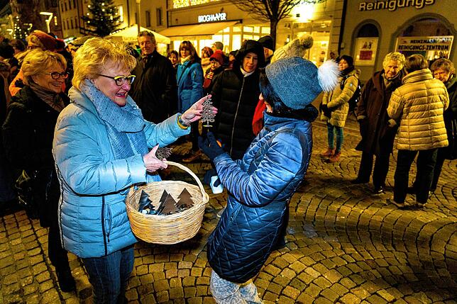 Margot Schaumann ist die gute Seele der Adventsfenster und fast jeden Abend vor Ort dabei, hier verteilt sie Tannenbaum-Kerzenständer ...