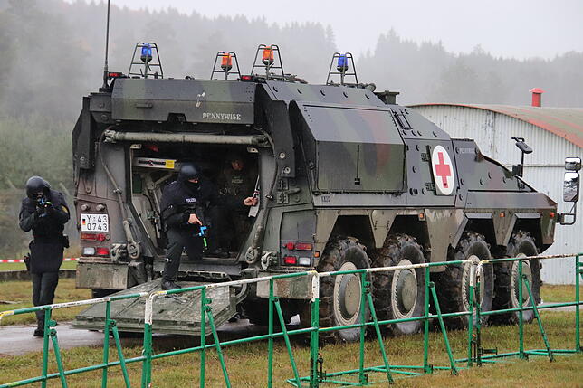 Ein GTK-&ldquo;Boxer&ldquo;-Panzer der Bundeswehr rollt in die Szenerie. Er kann den Polizisten Schutz bieten &ndash; und dabei helfen, ...