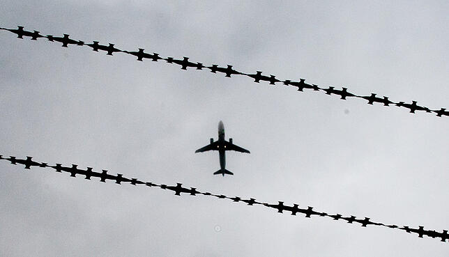 Ein Flugzeug ist hinter Stacheldraht zu sehen. Immer wieder kommt es vor, dass Flüchtlinge und Migranten erst nach Jahren, oft in einem ...