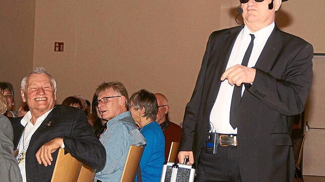 Als bisher unbekannter Bruder der bekannten Blues Brothers, ausstaffiert mit dem typischen Hut, Sonnenbrille und Koffer, tritt Pfarrer ...